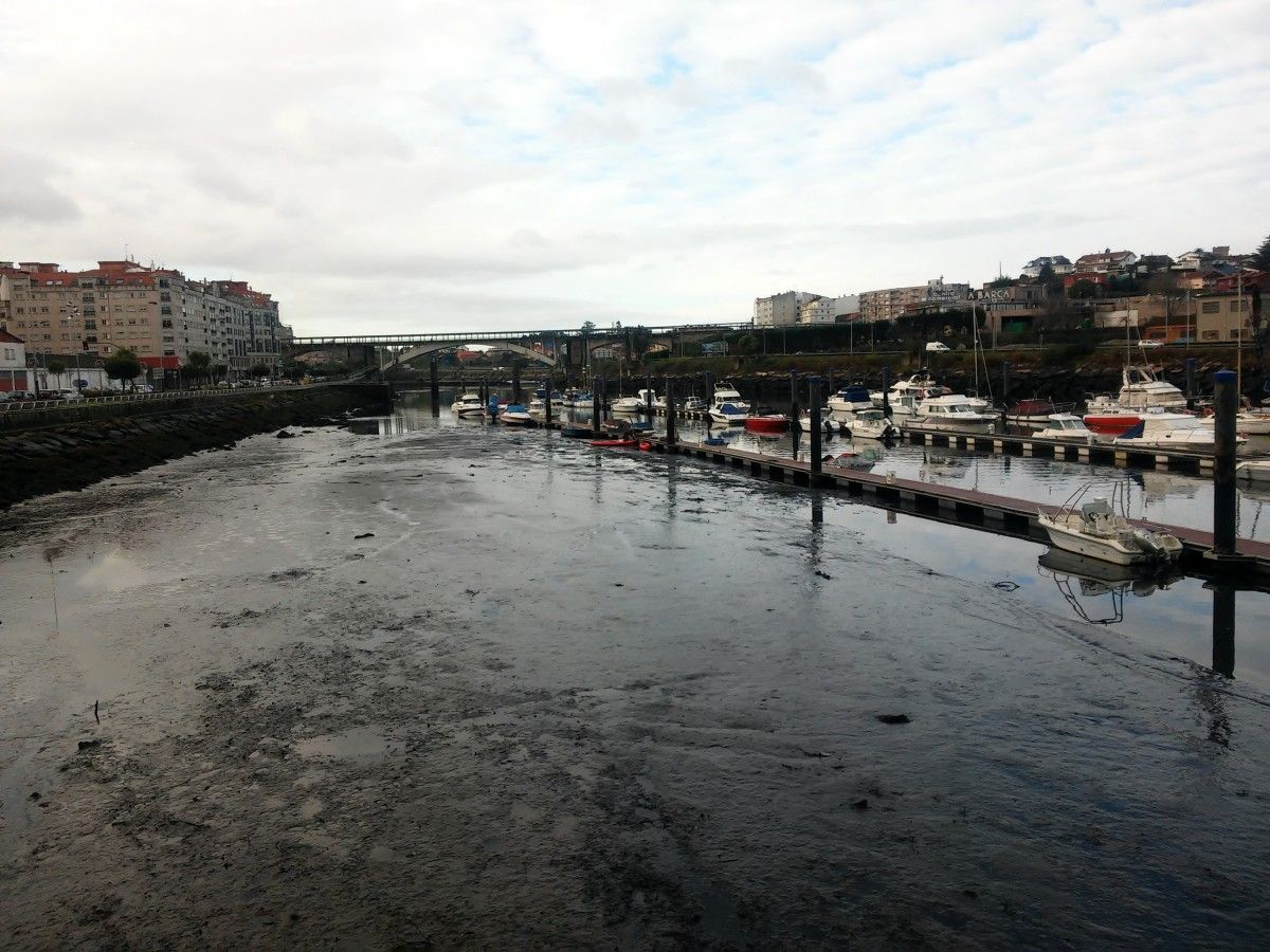 Magín Froiz e David Cal recollen lodo no río Lérez