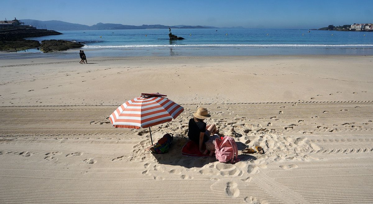 Persoa tomando o sol na praia de Silgar