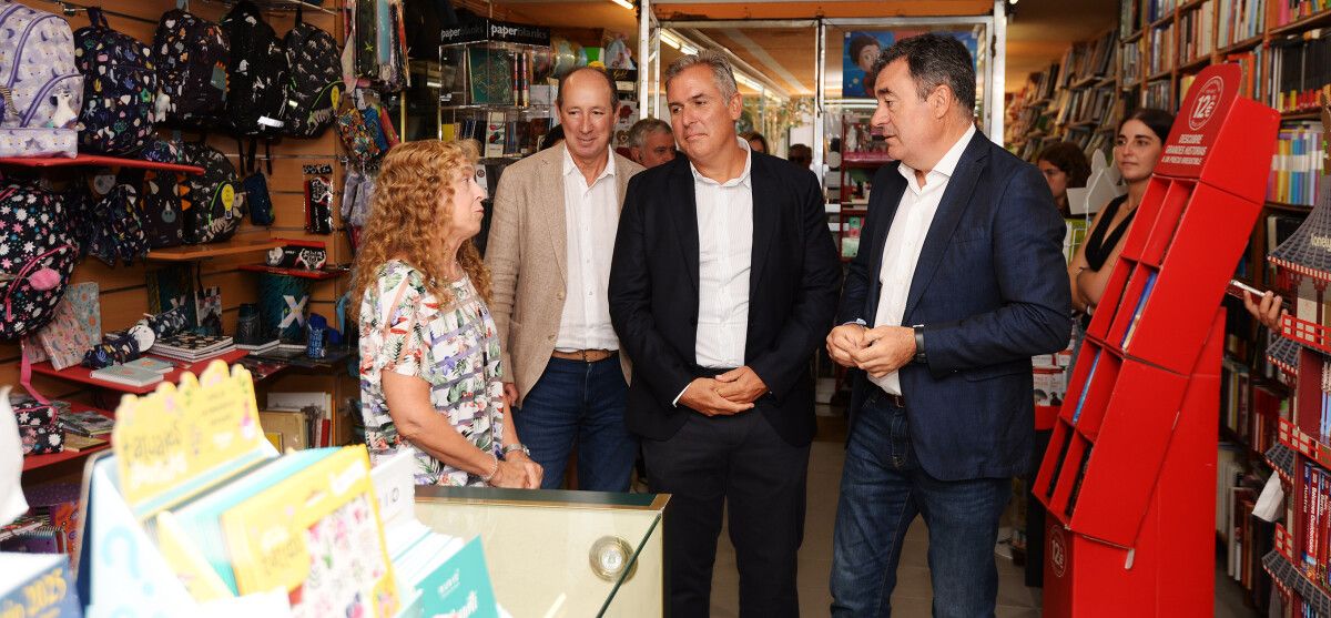 Jesús Manuel Álvarez Bértolo, Rafa Domínguez e Román Rodríguez charlan coa encargada de Librería Escolma
