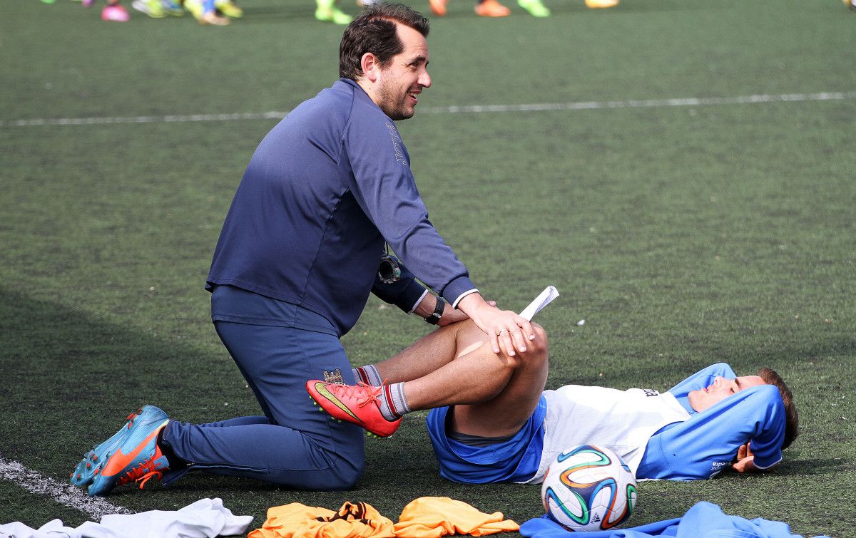 Benja realiza estiramientos en un entrenamiento con el preparador físico, Roberto Valdés