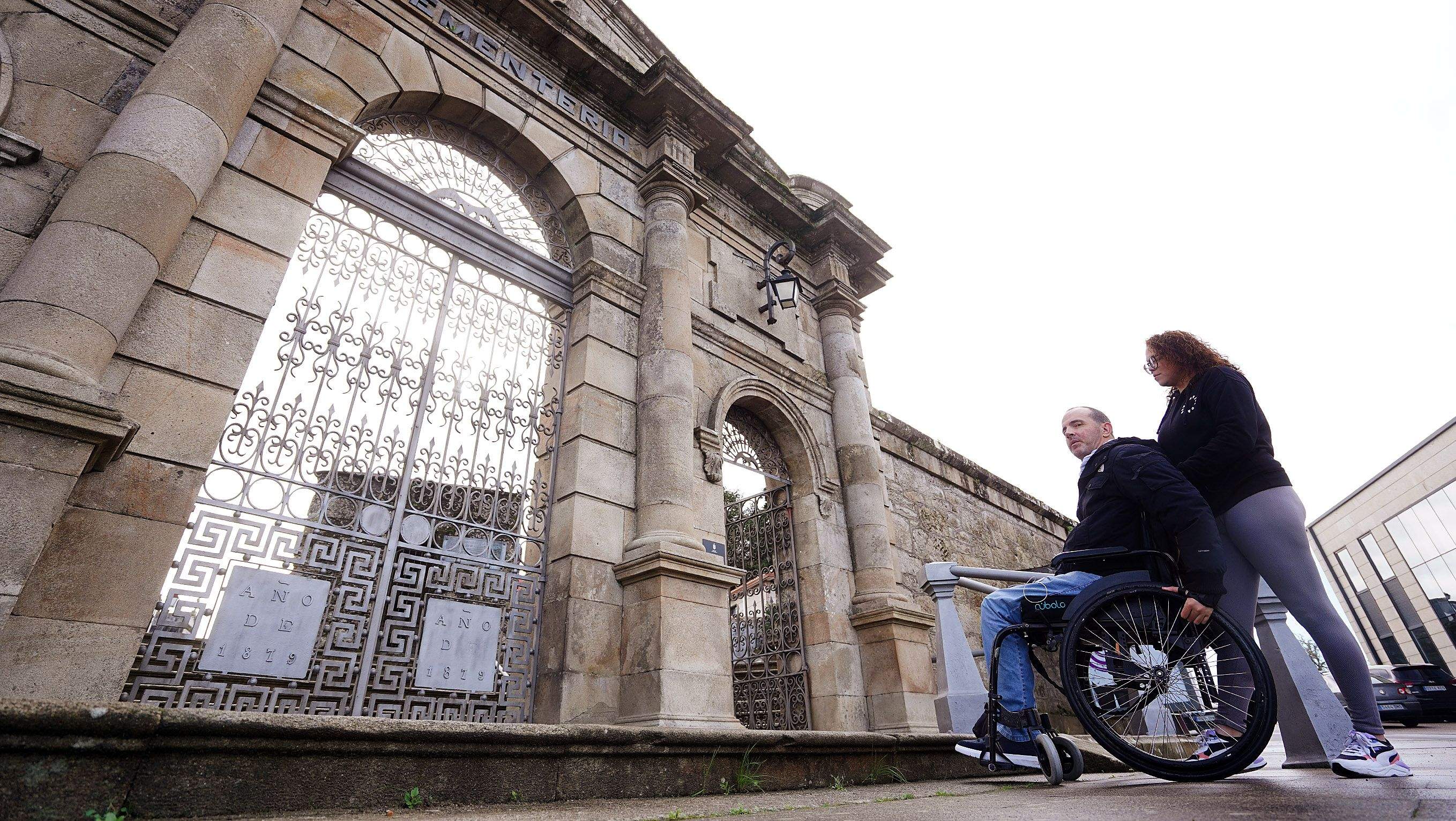 Paulo Fontán, presidente de Amizade, acompañado de su asistente, delante de la puerta principal del cementerio de San Mauro