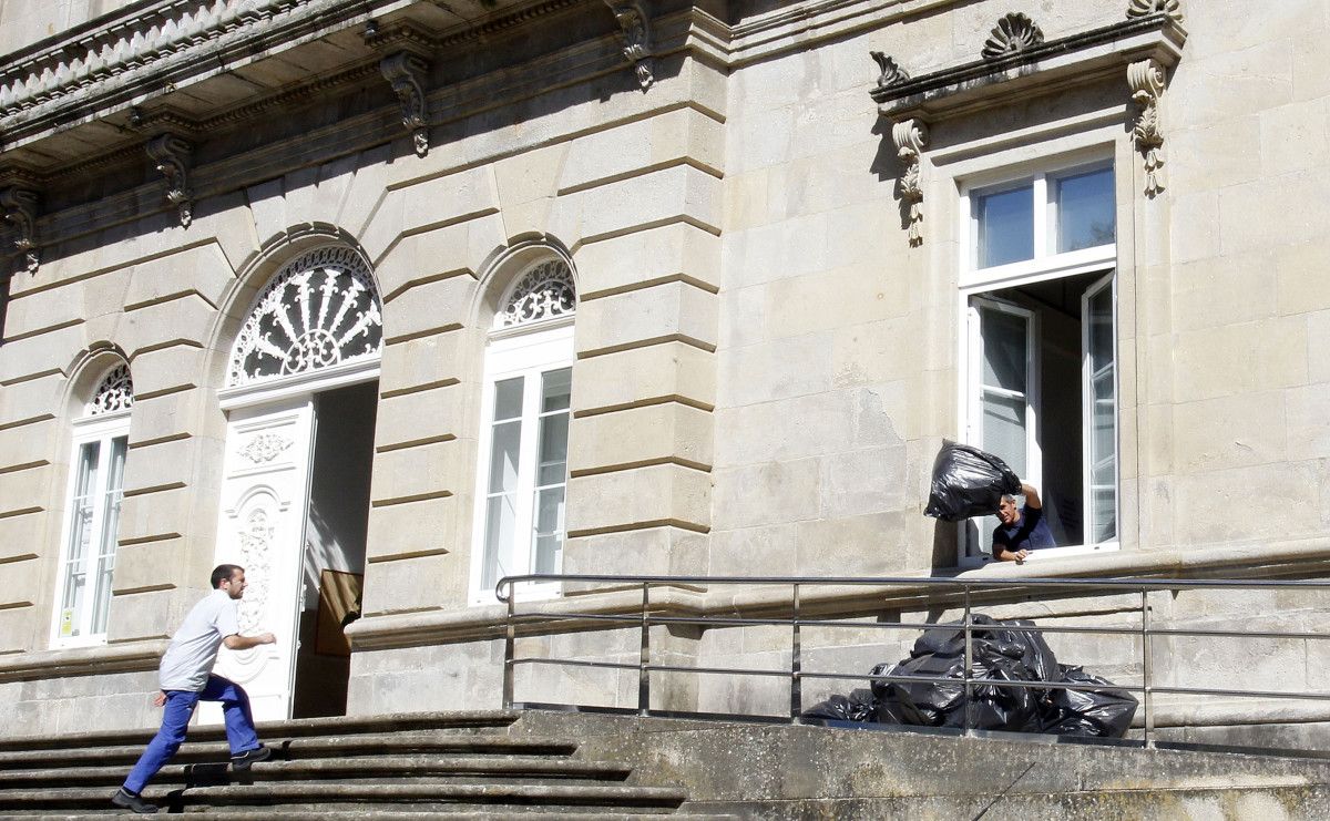 Operarios de Limpiezas Cíes sacando bolsas de basura por la ventana de la Deputación