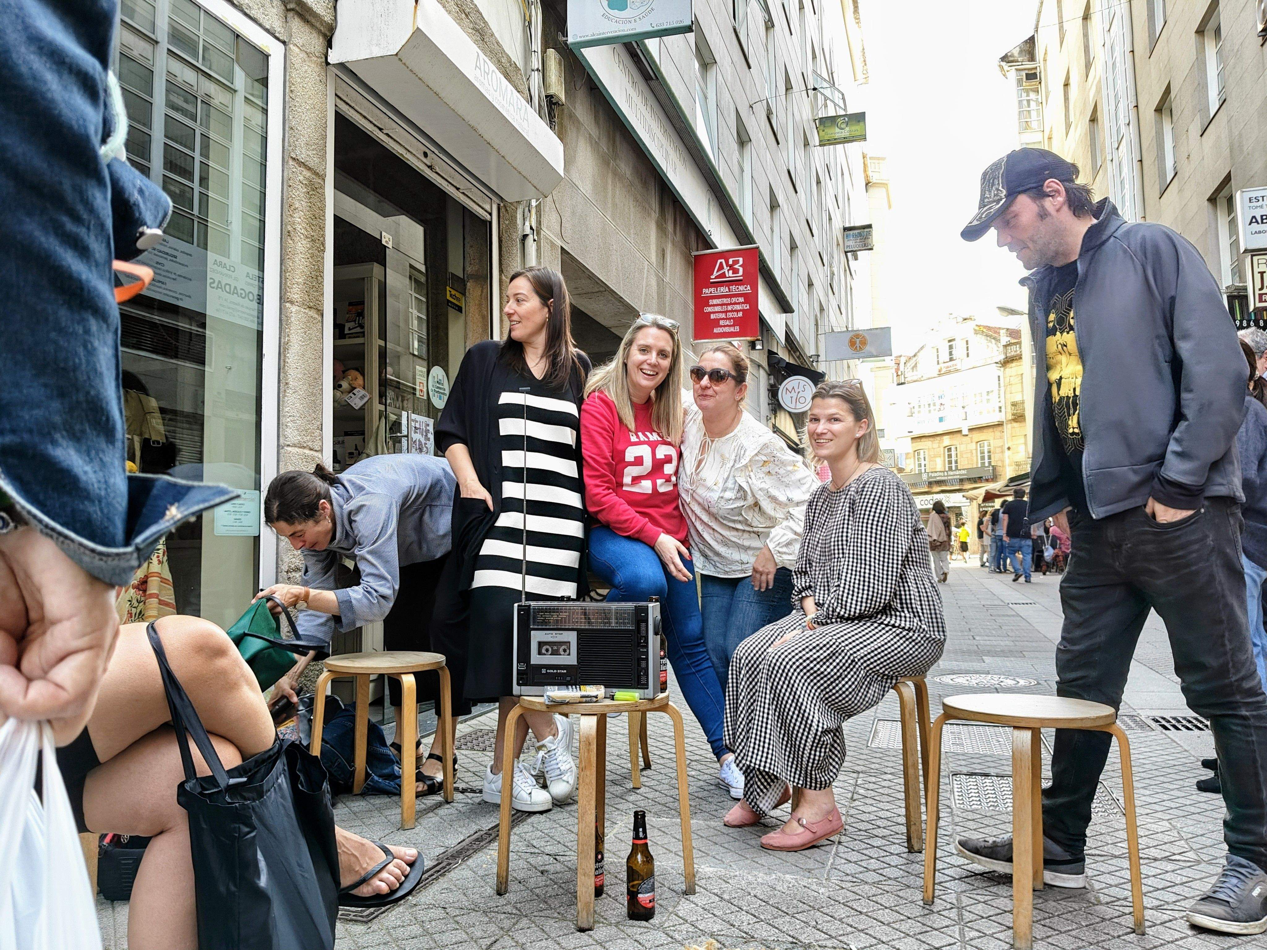 Grupo de personas alrededor de una radio a pilas en la calle Marquesa
