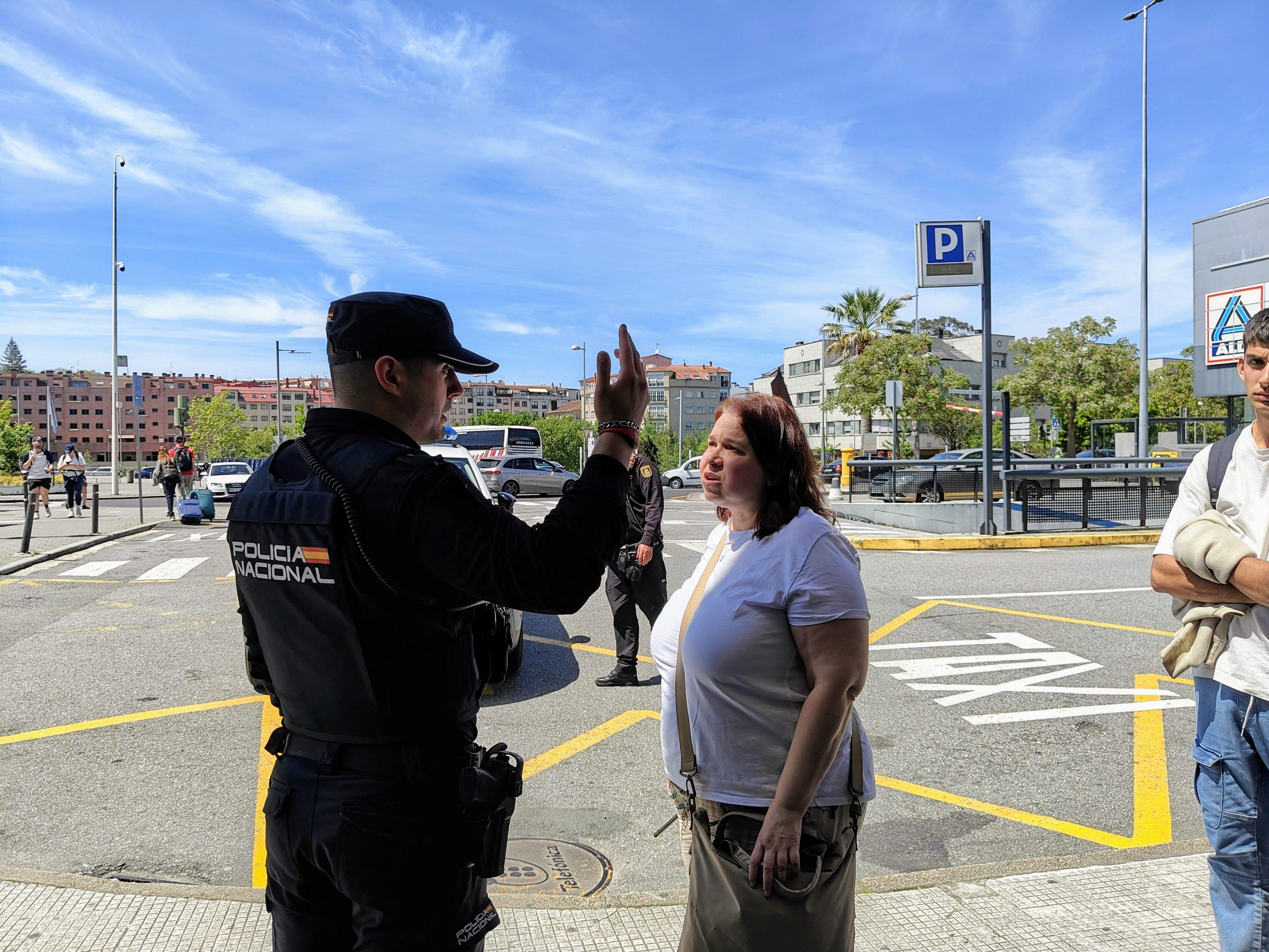 Un policía nacional explica la situación a una persona en la estación de trenes Un policía nacional explica la situación a una persona en la estación de trenes