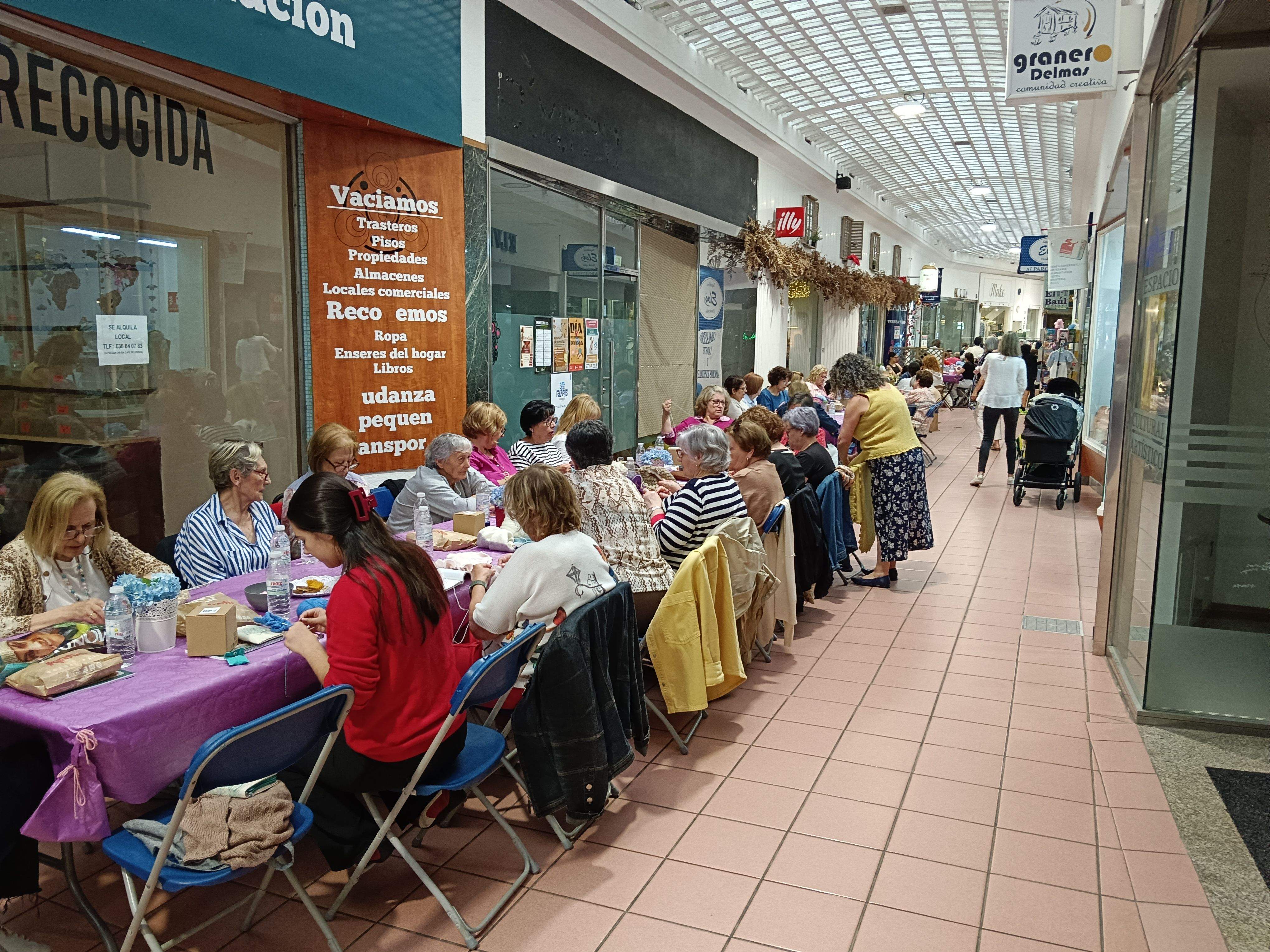 Persoas tecendo nas Galerías da Oliva
