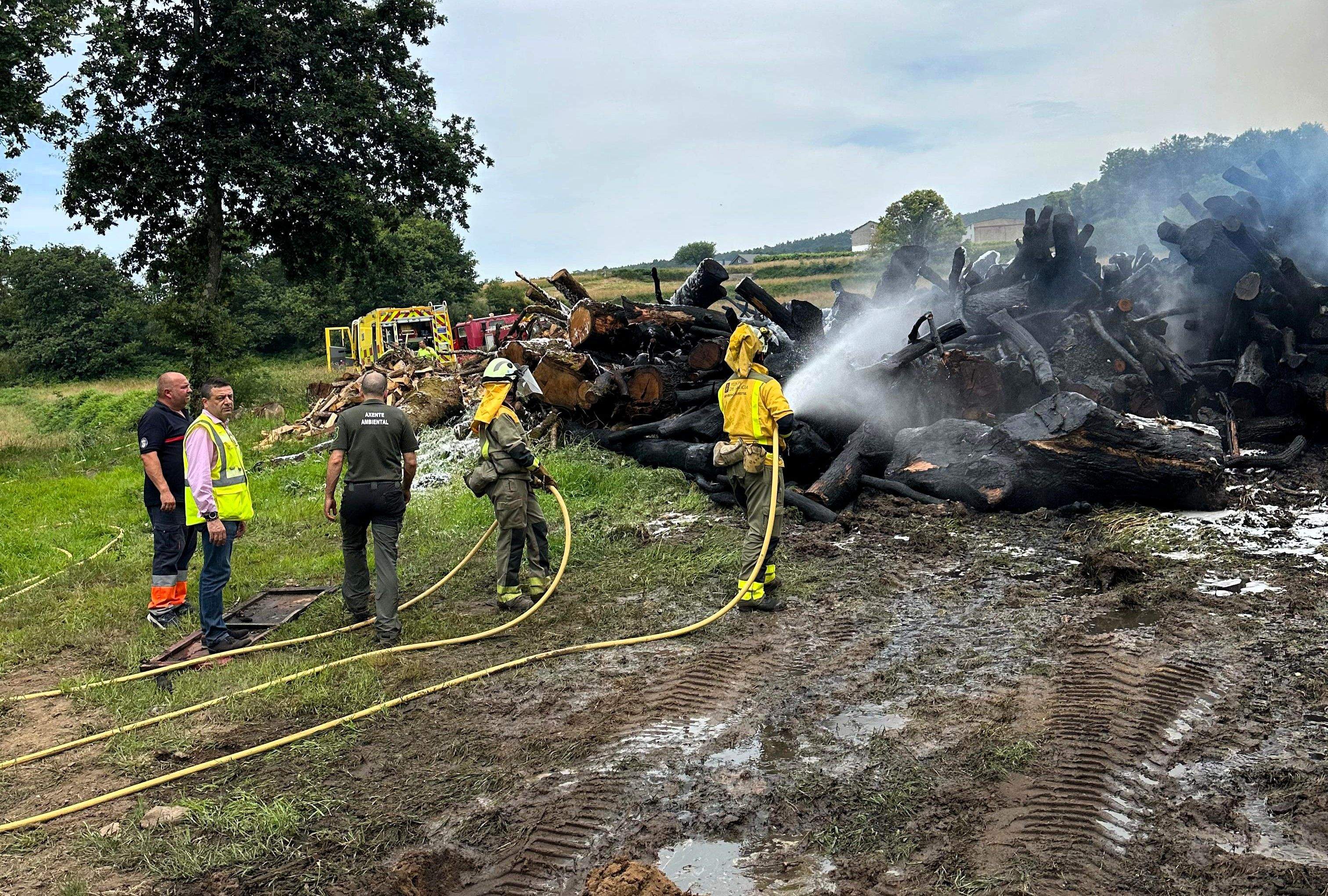Labores de extinción dun incendio nunha pila de leña en Arcos de Furcos