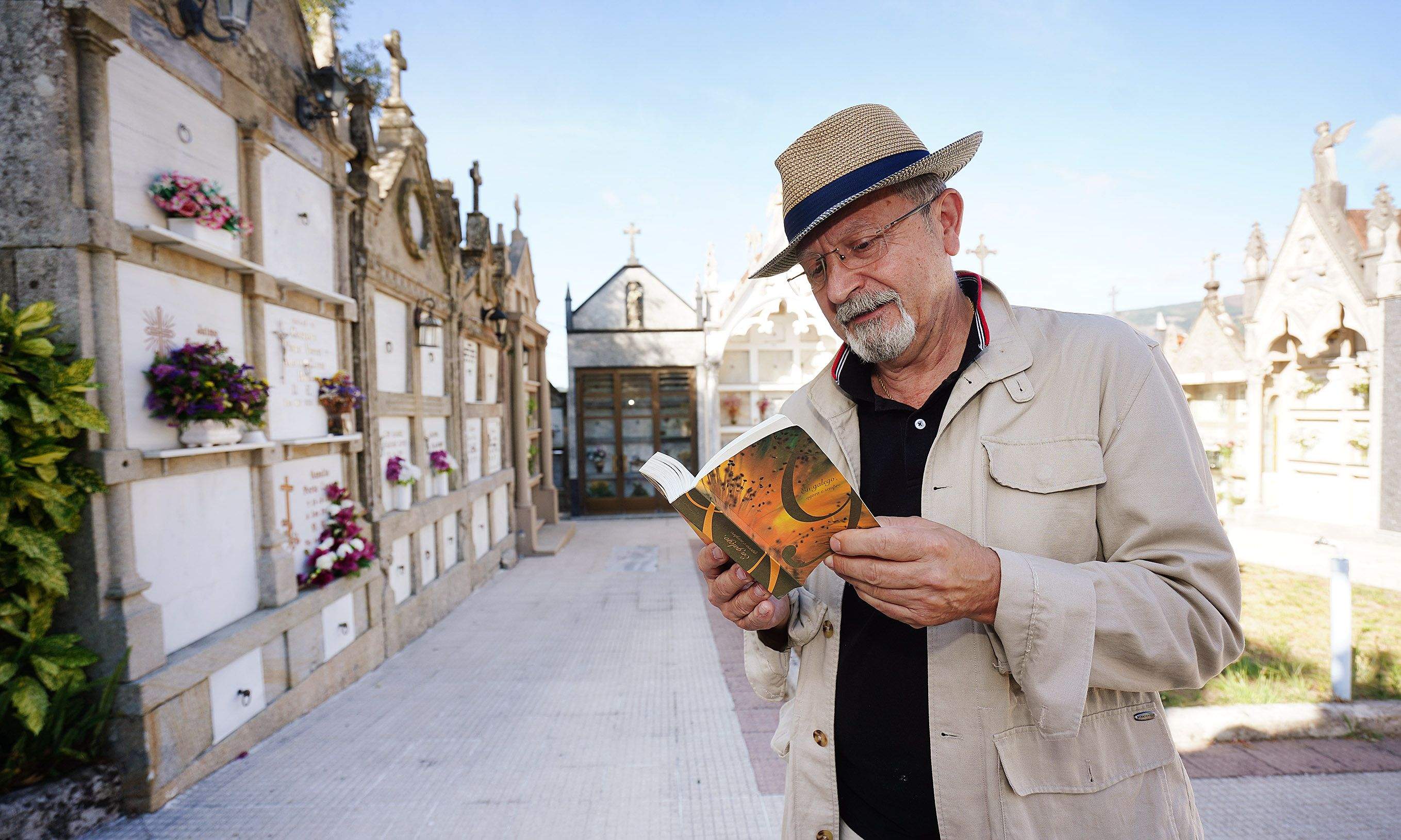 Juan José Esperón co libro 'En galego, agora e sempre' no cemiterio parroquial de San Vicente de Cerponzóns