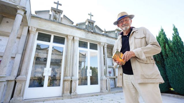 Juan José Esperón posa co libro 'En galego, agora e sempre' diante do panteón familia no cemiterio parroquial de San Vicente de Cerponzóns