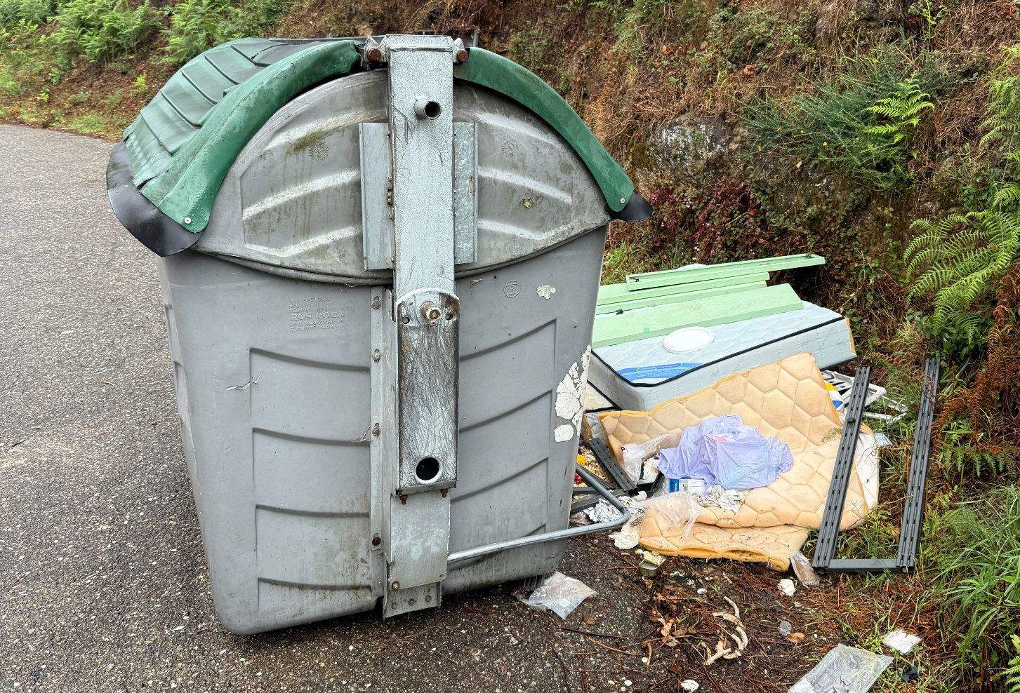 Basura alrededor del colector de basura en en O Ribeiro, en la parroquia de Campañó