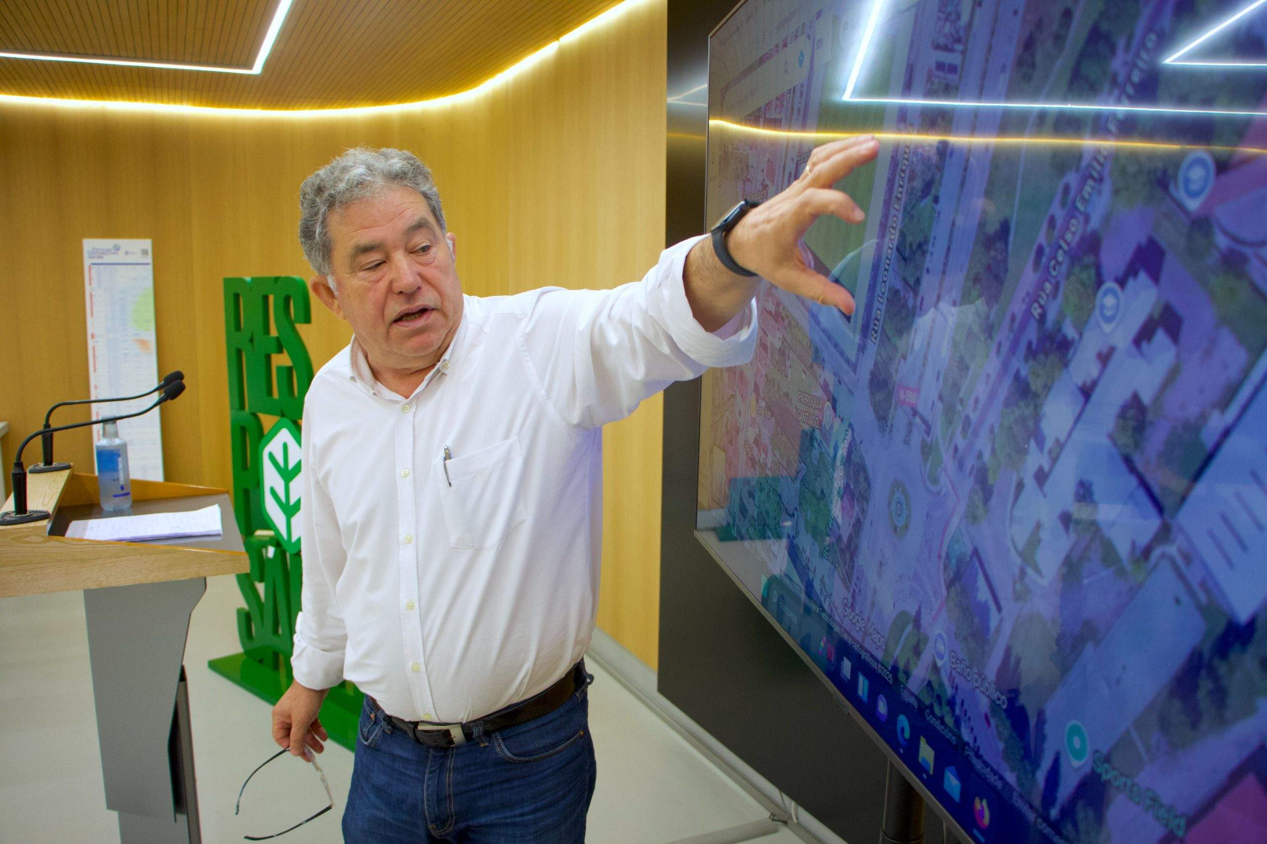 El alcalde señala sobre el mapa el terreno adquirido por el Concello