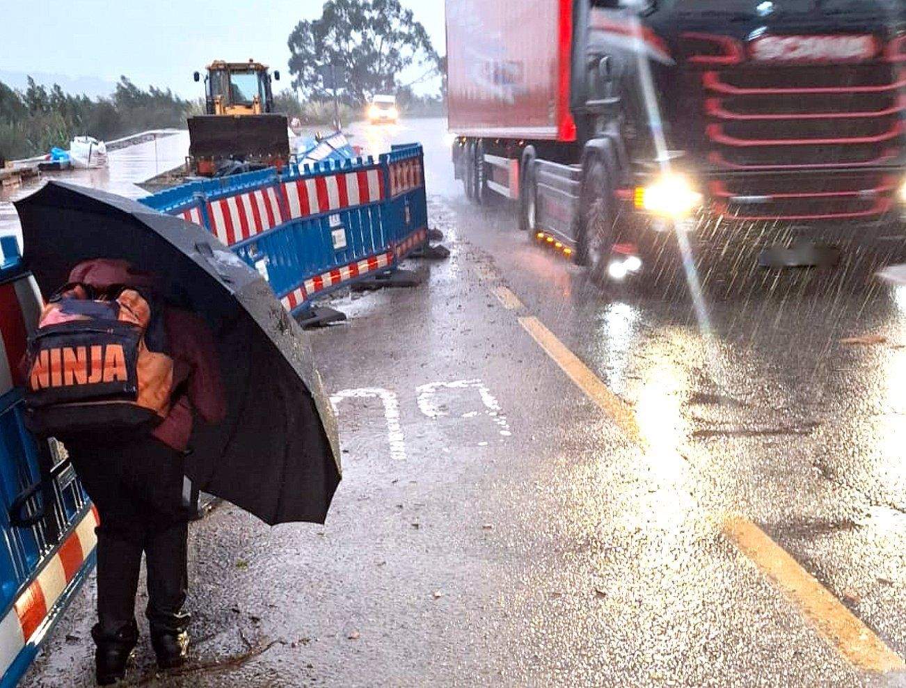 Escolar na parada de autobús ante o paso de camións na estrada vella de Marín