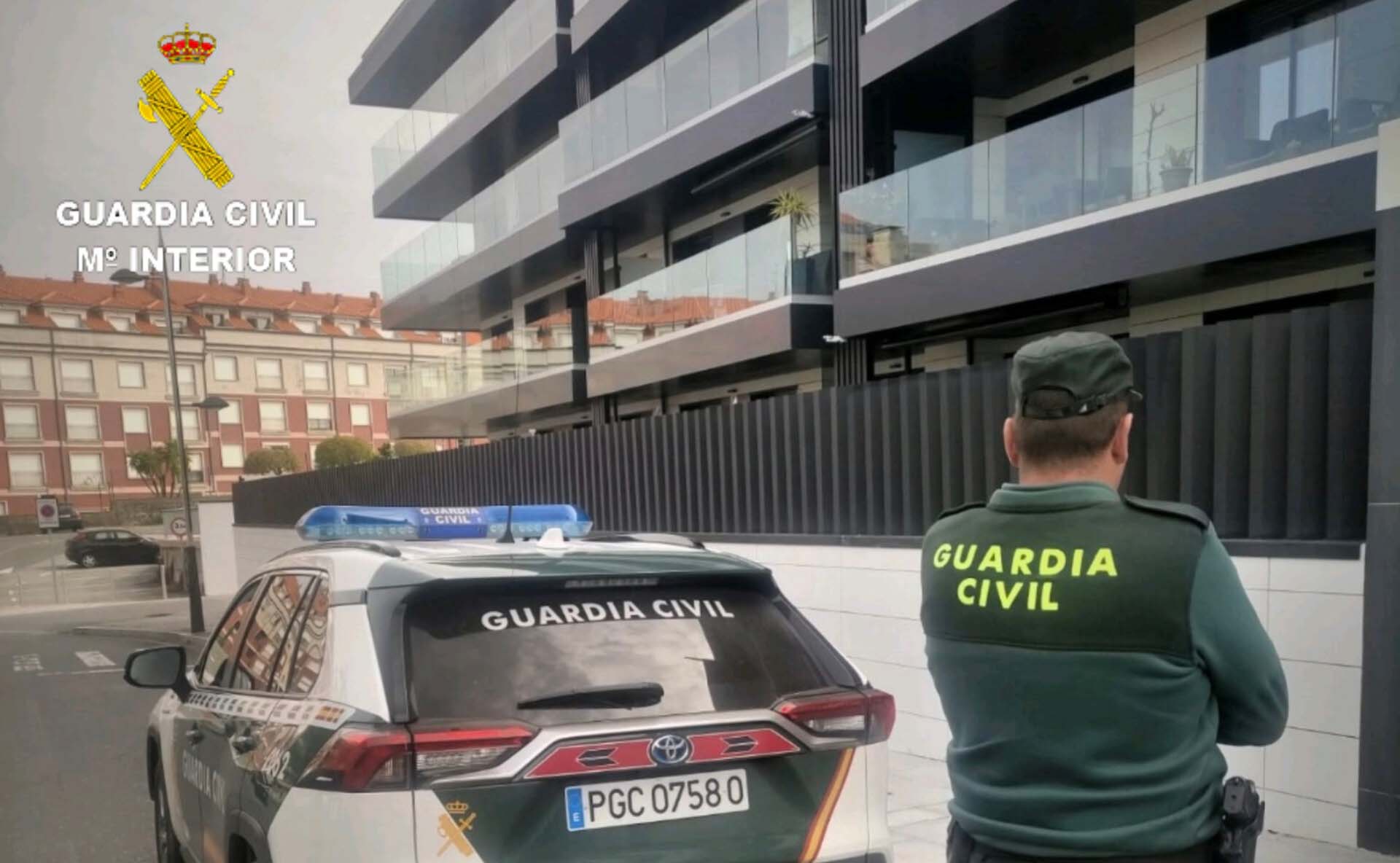Un agente de la Guardia Civil ante un edificio de apartamentos de Sanxenxo