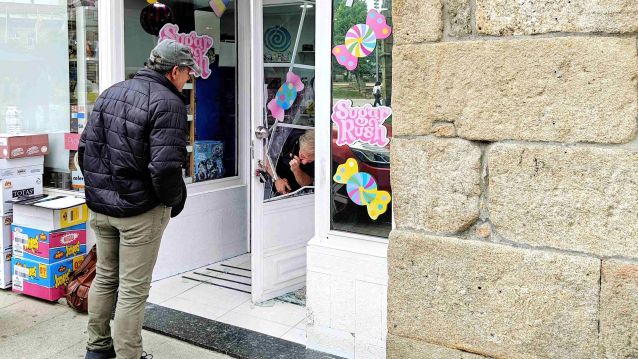 Un operario revisa os danos causados no acceso á tenda Sugar Rush