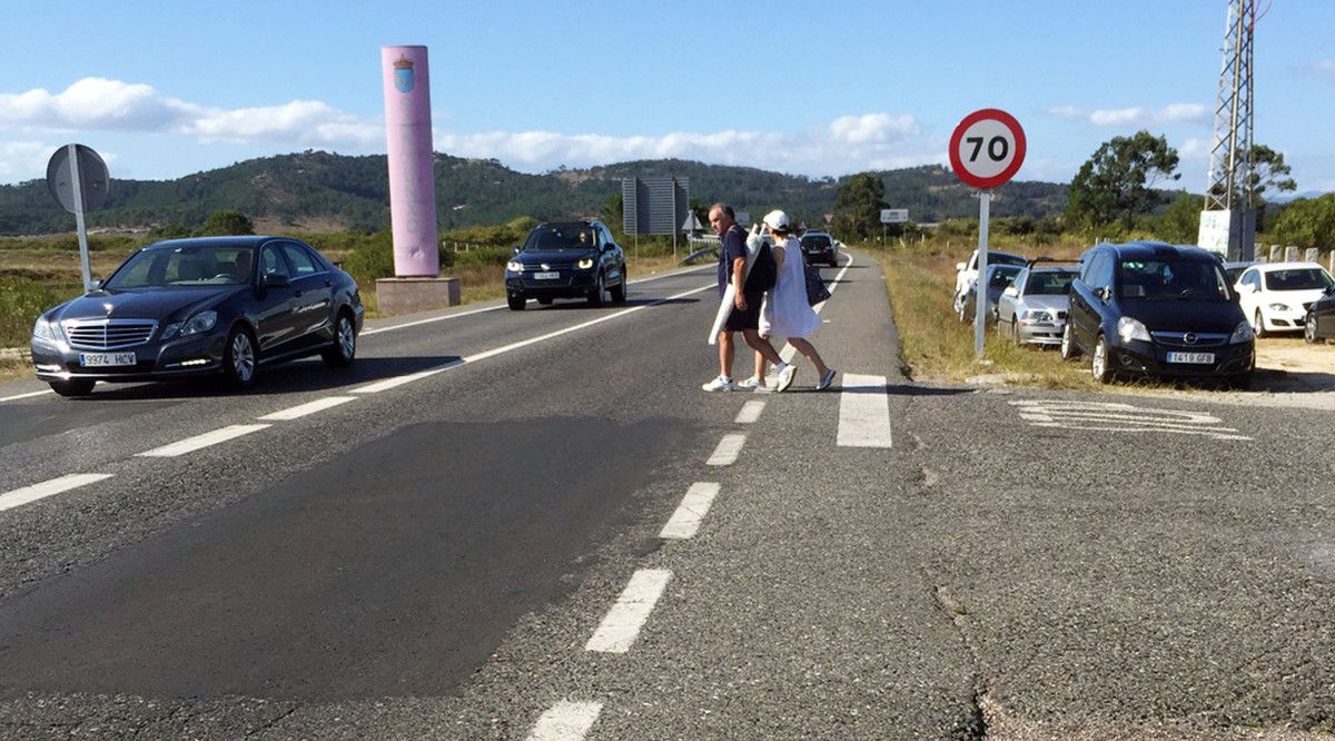 Peatones cruzando la calzada en la zona de As Salinas, en A Lanzada