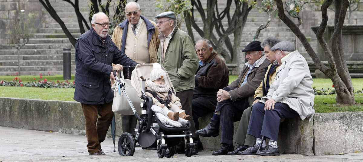 Un grupo de jubilados con un niño en la plaza de A Ferrería
