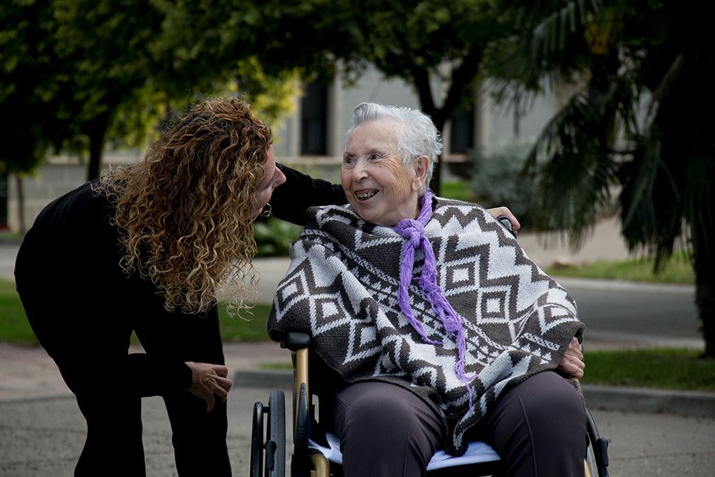 Una persona mayor con su cuidadora