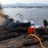 Tareas de extinción del incendio en el catamarán 'Boramar', totalmente calcinado y embarrancado en A Toxa