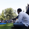 Militantes sentados por el suelo y otros resguardados del sol bajo los árboles durante la apertura del curso político del PP 2013