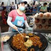 Muller a cociñar nun posto da rúa